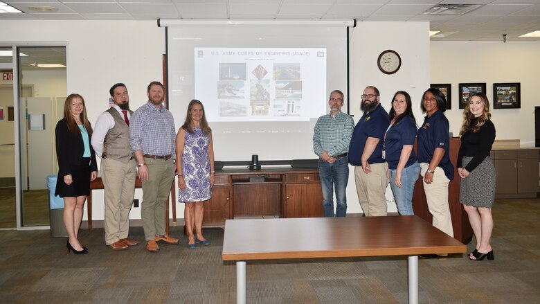 A group of employees stand with a group of teachers.