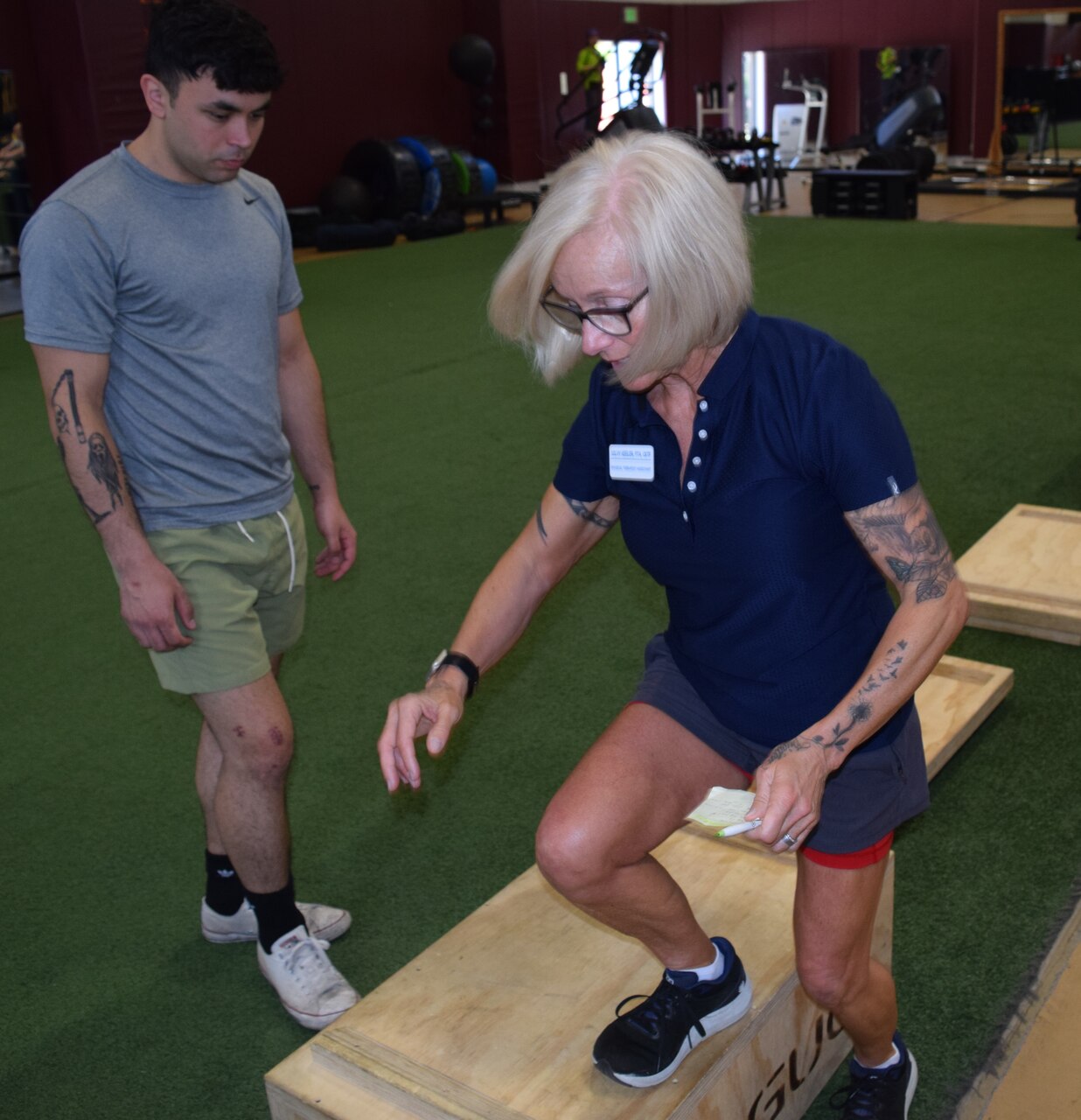 Taking a step towards recovery… Silvy Keeler, Naval Hospital Bremerton physical therapy assistant, instructs client Master-at-Arms 3rd Class Brendan Wilson assigned to Naval Base Kitsap on box drill exercises designed to stretch and strengthen key joints such as hips and ankles, along with related muscles like hamstrings and calves to help him repair his knee after an anterior cruciate ligament tear (official Navy photo by Douglas H Stutz, NHB/NMRTC Bremerton public affairs officer).