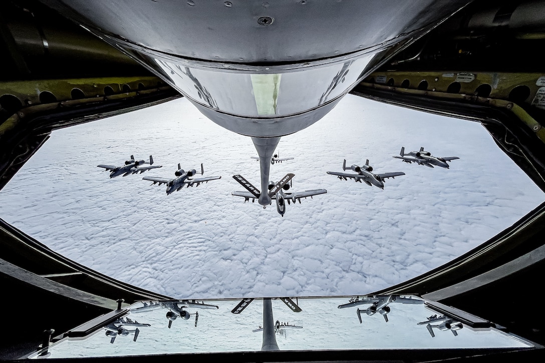 An Air Force A-10 Thunderbolt II aircraft flies in formation behind a KC-135 Stratotanker.
