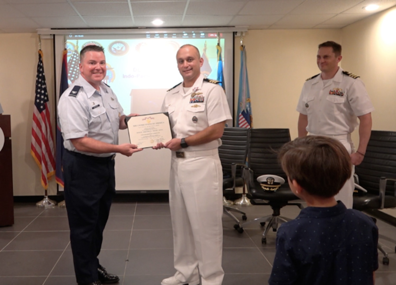 an Air Force officer and Navy officer in unform shaking hands