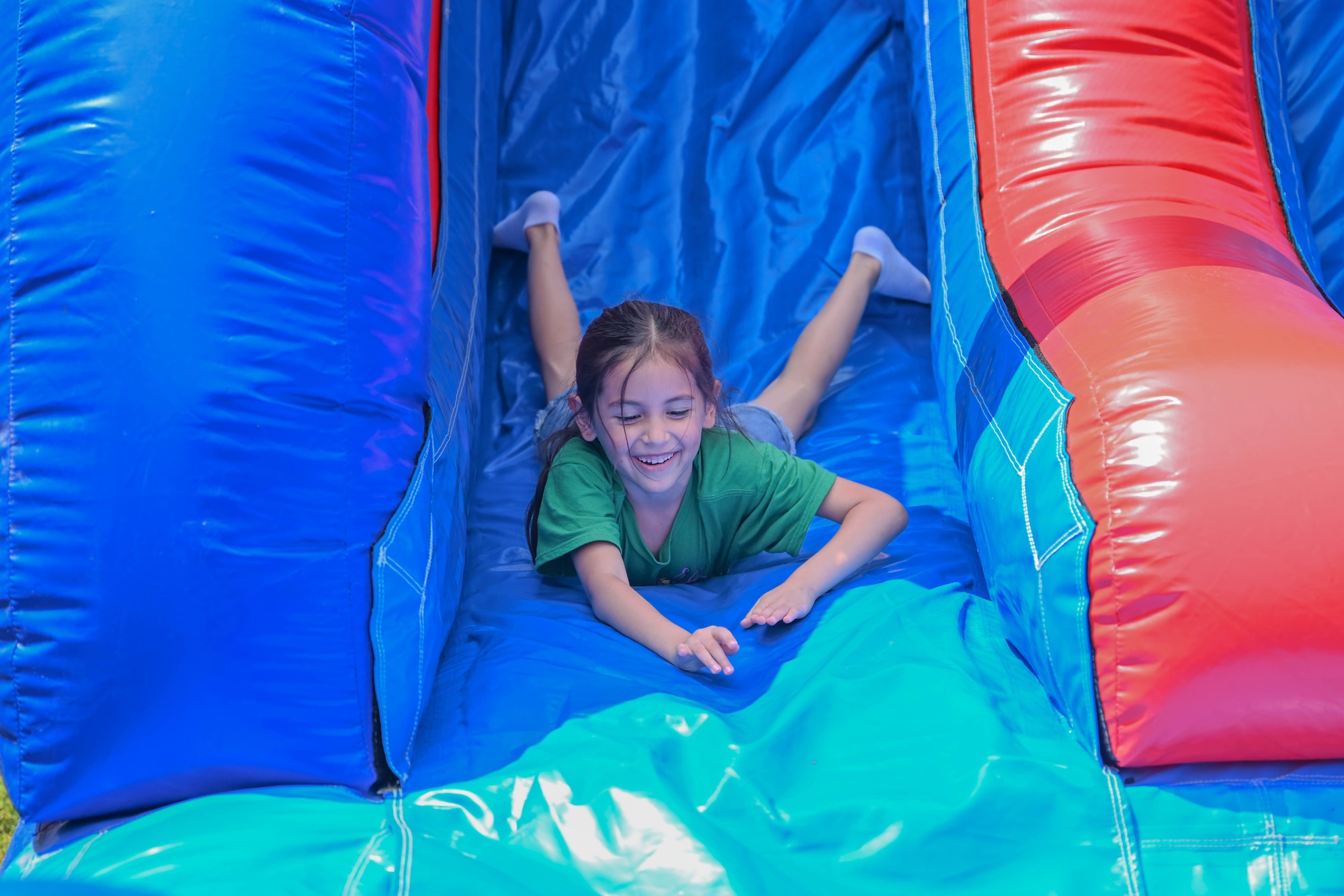 girl slides down a bounce house