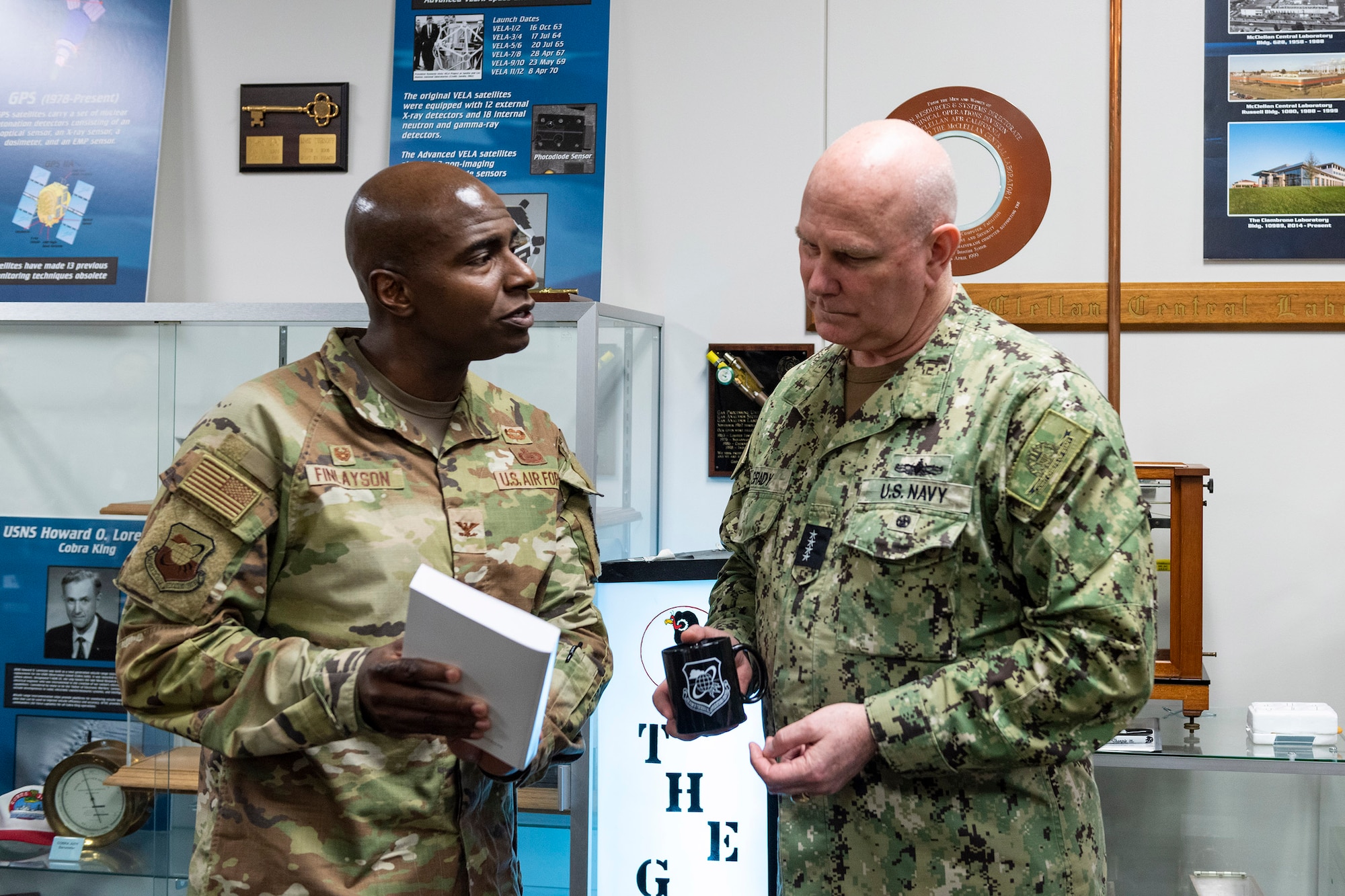 Col. James A. Finlayson (left), commander of the Air Force Technical Applications Center, Patrick Space Force Base, Fla., presents a book to Admiral Christopher W. Grady, Vice Chairman of the Joint Chiefs of Staff, during the vice chairman’s visit to the nuclear treaty monitoring center June 9, 2023.  During his visit, the admiral was briefed on AFTAC’s persistent surveillance capabilities, directed energy weapons programs, as well as the center’s Nuclear Debris, Collection and Analysis program.  (U.S. Air Force photo by Matthew S. Jurgens)