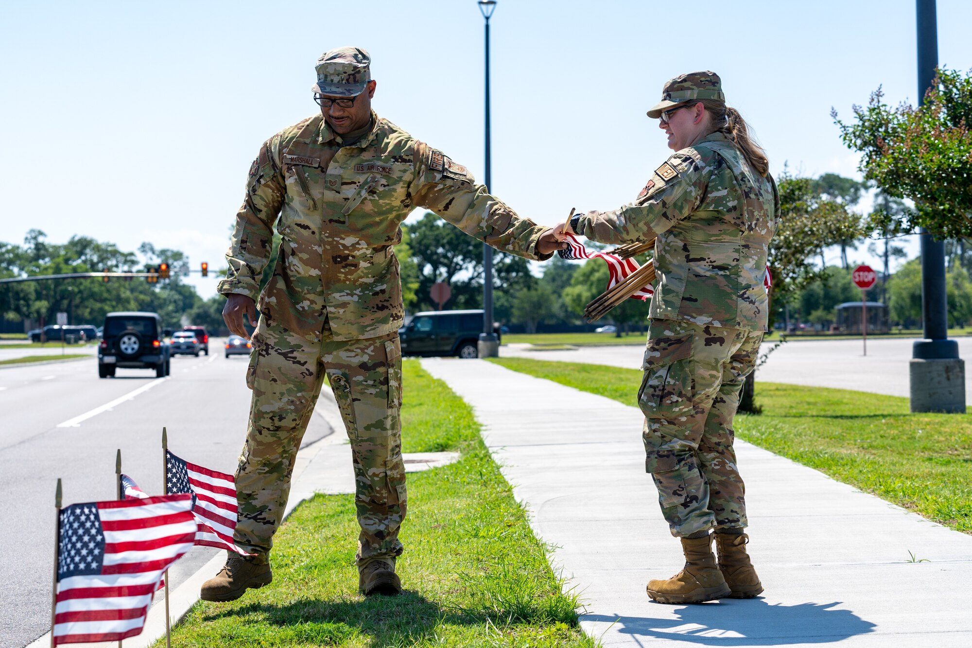 U.S. Air Force Tech. Sgt. Anthony Marshall, 81st Civil Engineer Squadron chief of health and safety, and Airman 1st Class Liberty Barrett, 81st Operational Medical Readiness Squadron medical technician, place flags at Keesler Air Force Base, Mississippi, June 12, 2023.