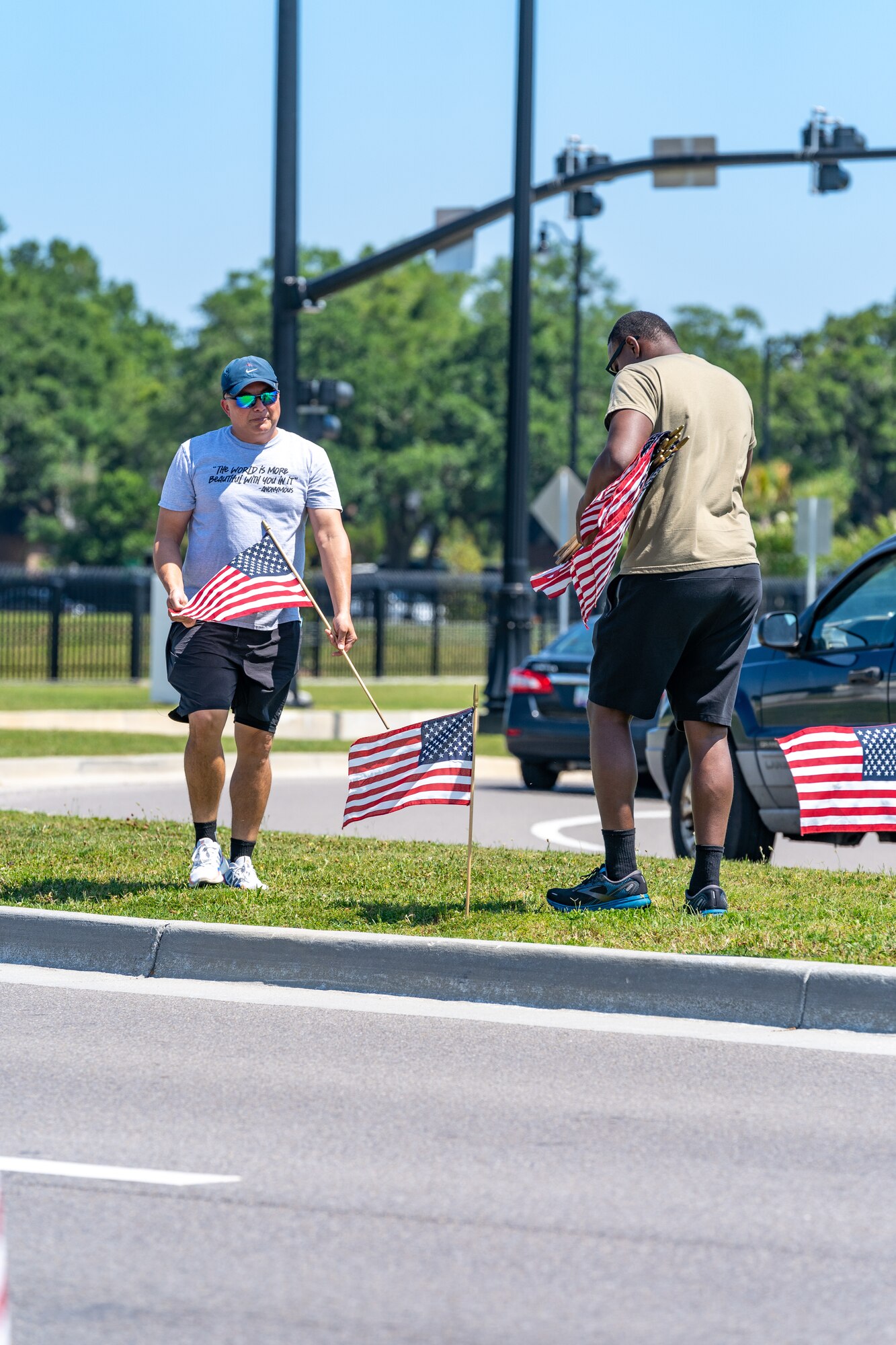 U.S. Air Force Senior Airman Darren Perry, 85th Engineering Installation Squadron cable and antenna systems, and Dan Kazumura, Air Force Sergeants Association chapter 652 president, place flags at Keesler Air Force Base, Mississippi, June 12, 2023.