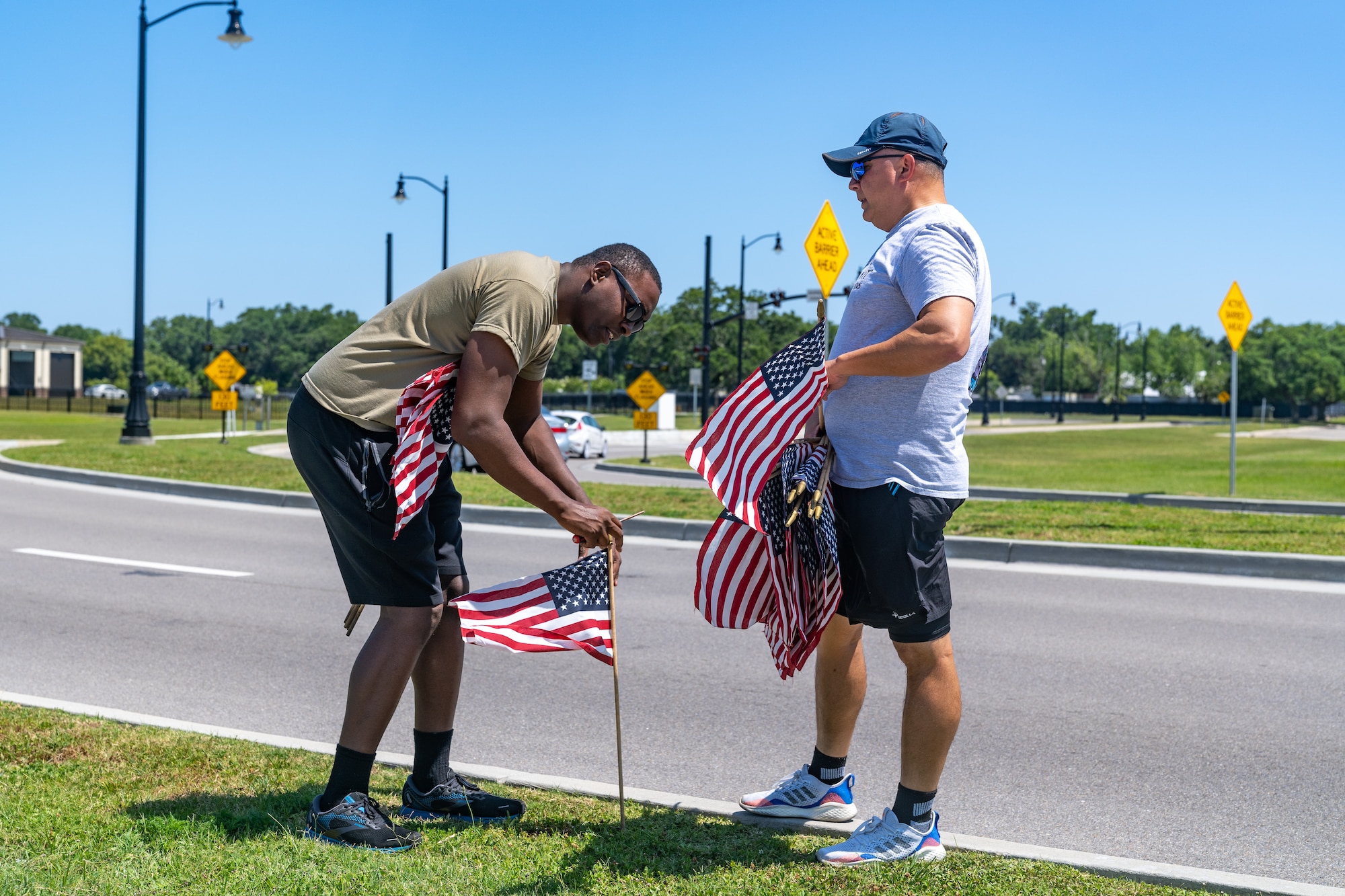 U.S. Air Force Senior Airman Darren Perry, 85th Engineering Installation Squadron cable and antenna systems, and Dan Kazumura, Air Force Sergeants Association chapter 652 president, place flags at Keesler Air Force Base, Mississippi, June 12, 2023.