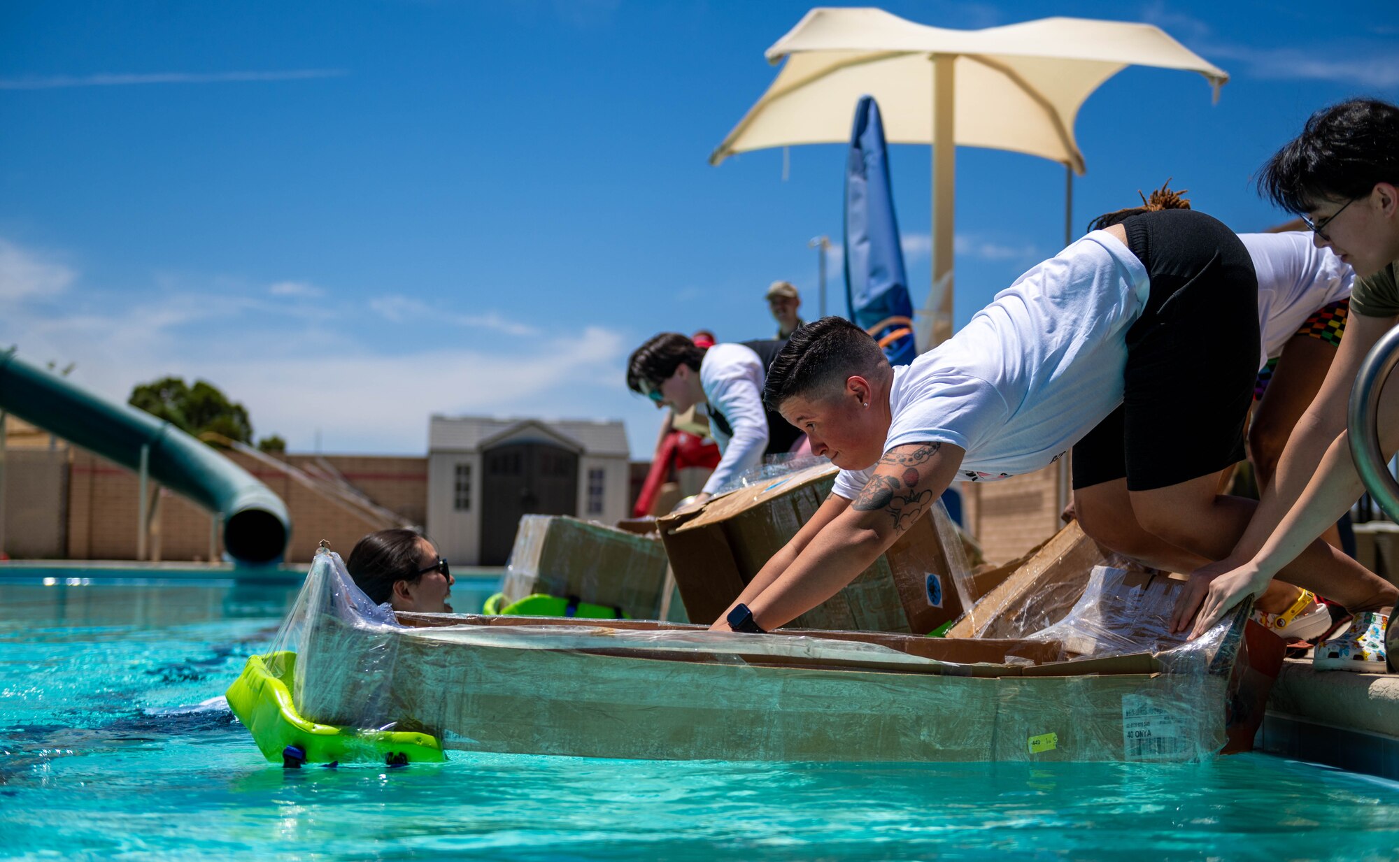 U.S. Air Force Master Sgt. Melissa Lord, 56th Component Maintenance Squadron fuels section chief, prepares to race her cardboard boat during a Pride Month event hosted by the Luke Pride Committee, June 9, 2023, at Luke AFB, Arizona.