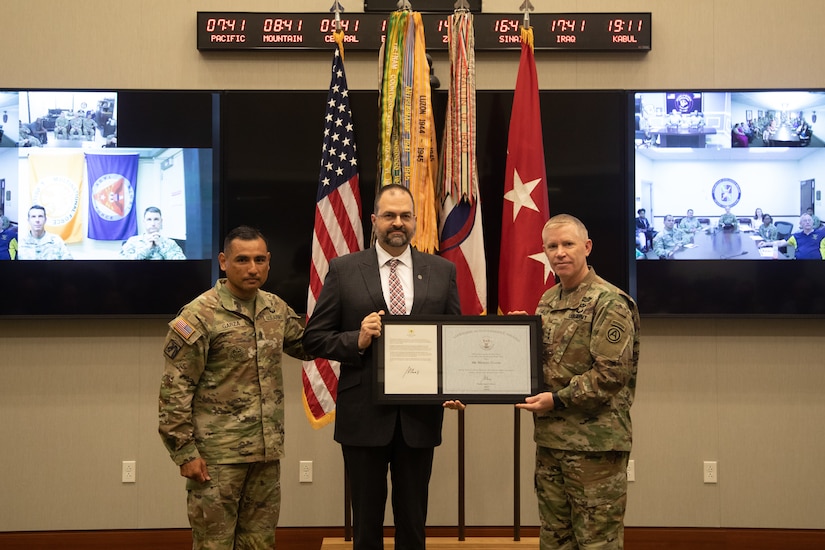 (right)Lt. Gen. Patrick Frank, U.S. Army Central commanding general, and (left)Command Sgt. Maj. J Garza, USARCENT senior enlisted leader, present (center) Mr. Michael Clauss, USARCENT's historian