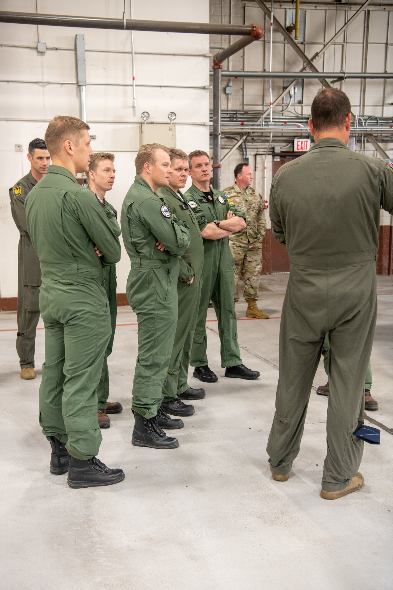 pilots talking around F-22 in hangar