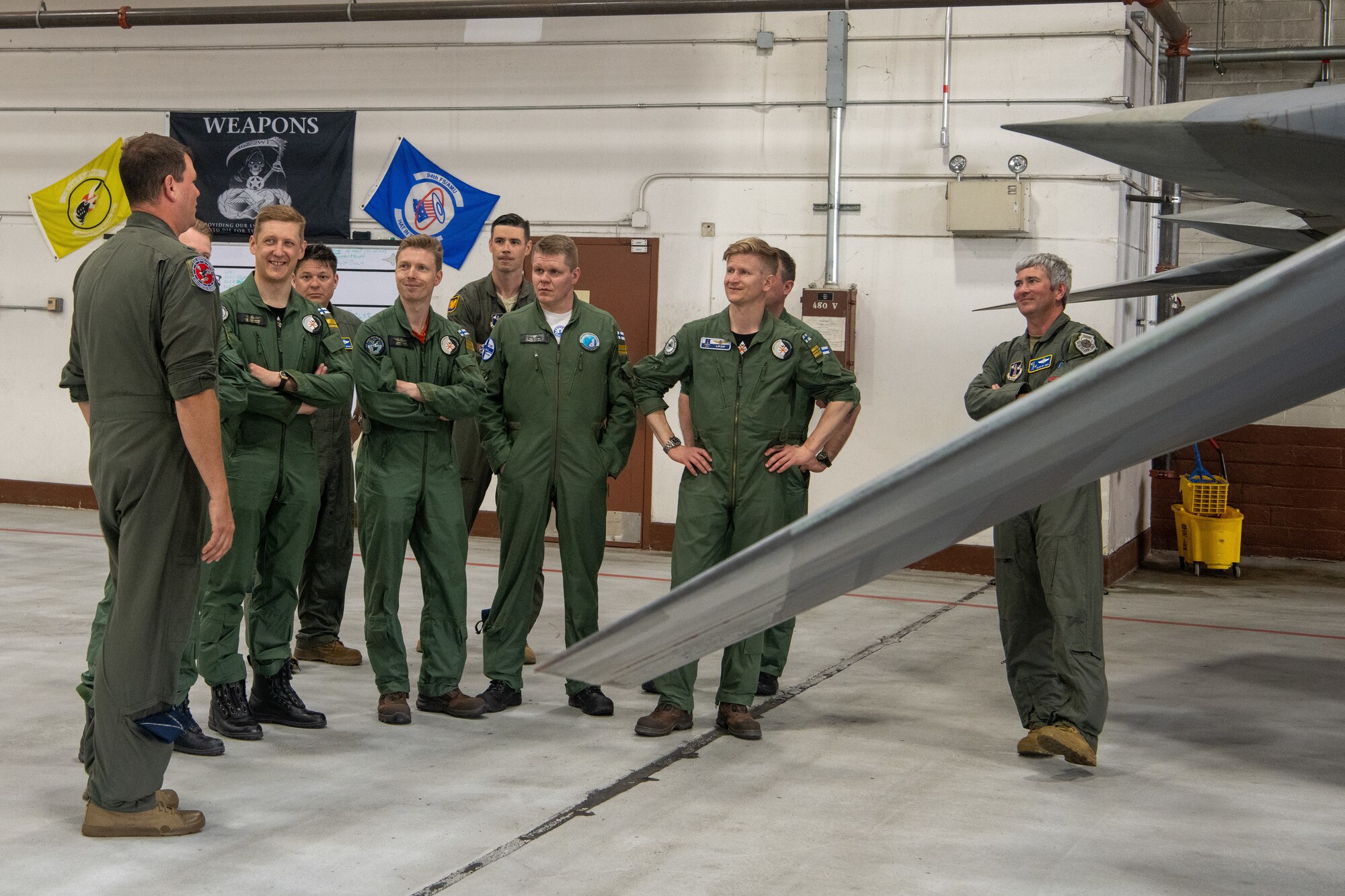 pilots talking around F-22 in hangar