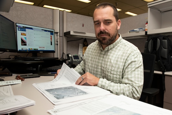 Brandon Whitley, civil site engineer with the Civil Design Branch in Nashville, Tennessee, is the U.S. Army Corps of Engineers Nashville District Employee of the Month for April 2023. He is seen here June 13, 2023, looking at site designs at his desk for the detention structure project in Cleveland, Tennessee. (USACE Photo by Lee Roberts)