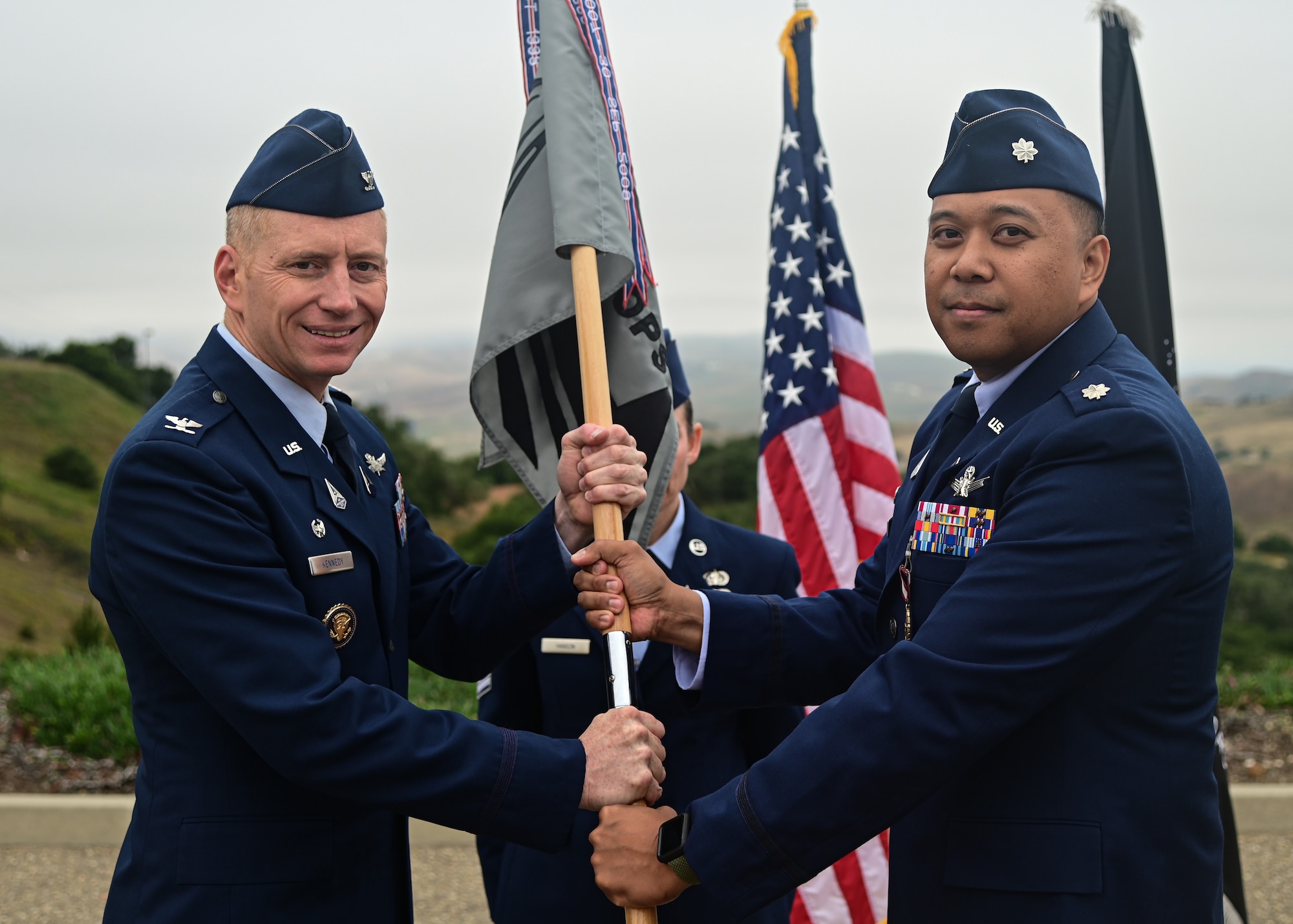 U.S. Space Force Lt. Col. Justin Roque, outgoing 21st Space Operations Squadron commander, passes the 21st SOPS flag to U.S. Space Force Col. Christopher Kennedy, Space Delta 6 commander, during a change of command ceremony on Vandenberg Space Force Base, Calif., June 9, 2023. Roque relinquished his command to U.S. Space Force Lt. Col. Matthew Knepper. (U.S. Space Force Photo by Airman 1st Class Ryan Quijas)