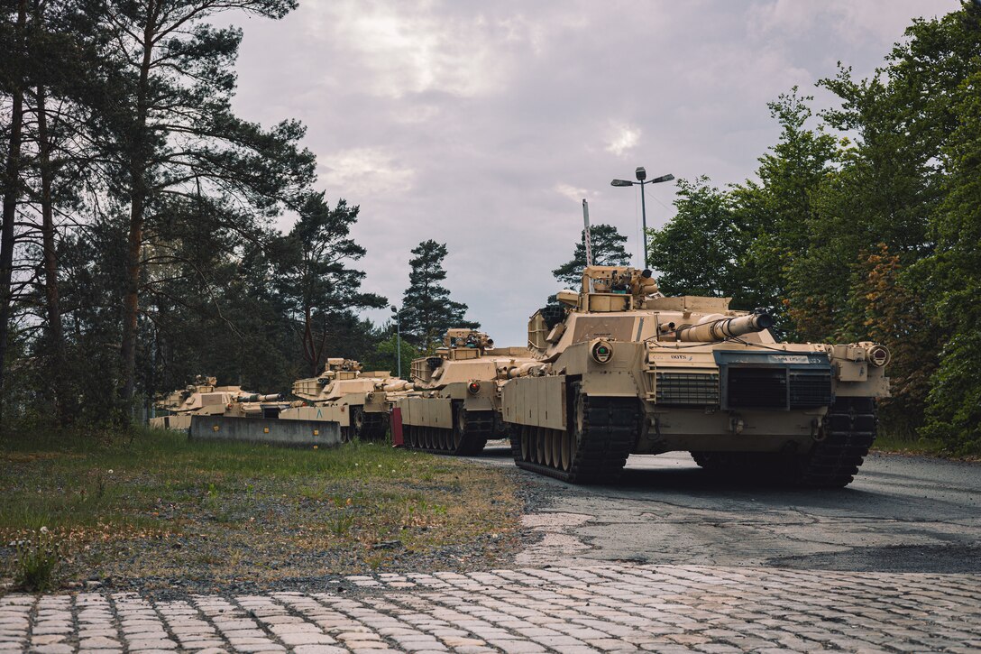 Tanks are lined up on a road.
