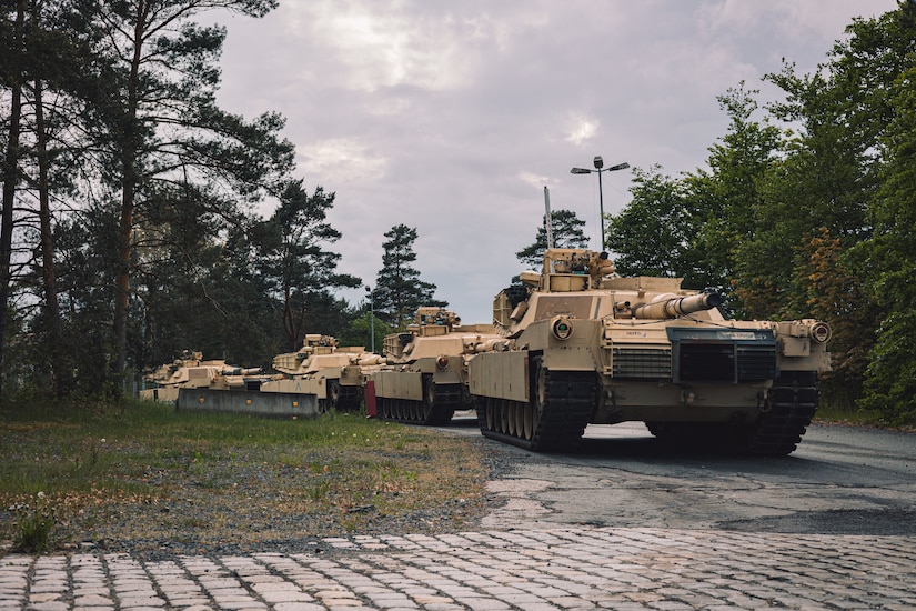 Tanks are lined up on a road.