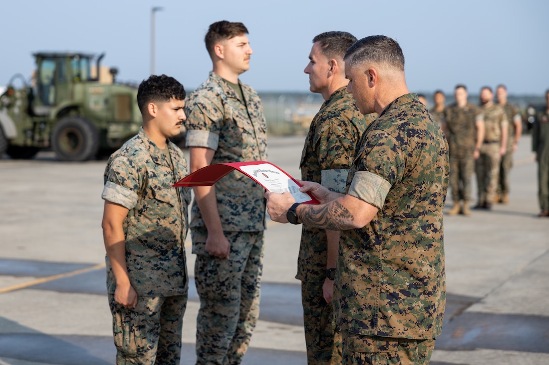 U.S. Marine Corps Sgt. Maj. Thomas Smith, the sergeant major of Marine Unmanned Aerial Vehicle Squadron (VMU) 2, reads an award citation at Marine Corps Air Station Cherry Point, North Carolina, May 22, 2023. U.S. Marine Corps Cpl. Jose Arispe and Cpl. John Graham, both unmanned aerial vehicle avionics technicians with VMU-2, were awarded certificates of commendation for their actions in response to a vehicle crash while off duty. VMU-2 is a subordinate unit of 2nd Marine Aircraft Wing, the aviation combat element of II Marine Expeditionary Force. (U.S. Marine Corps photo by Lance Cpl. Elias E. Pimentel III)