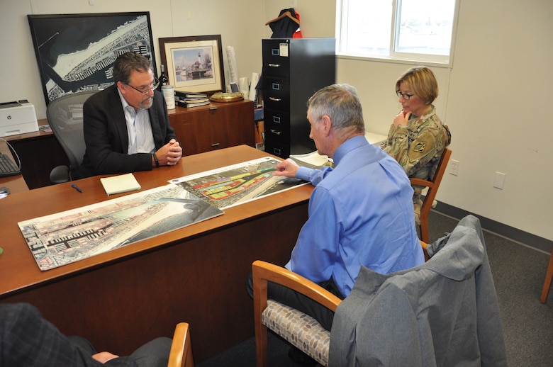 During a May 22 meeting in Oxnard, California, Channel Islands Harbor director Michael Tripp uses photographic maps to illustrate how sand filling the channel from tides and storms requires regular maintenance work on the breakwater and entrance channel, and how the severe winter storms affected navigation. Listening to Tripp are Col. Julie Balten, right, U.S. Army Corps of Engineers Los Angeles District commander, and Steve Dwyer, LA District Navigation Branch chief.