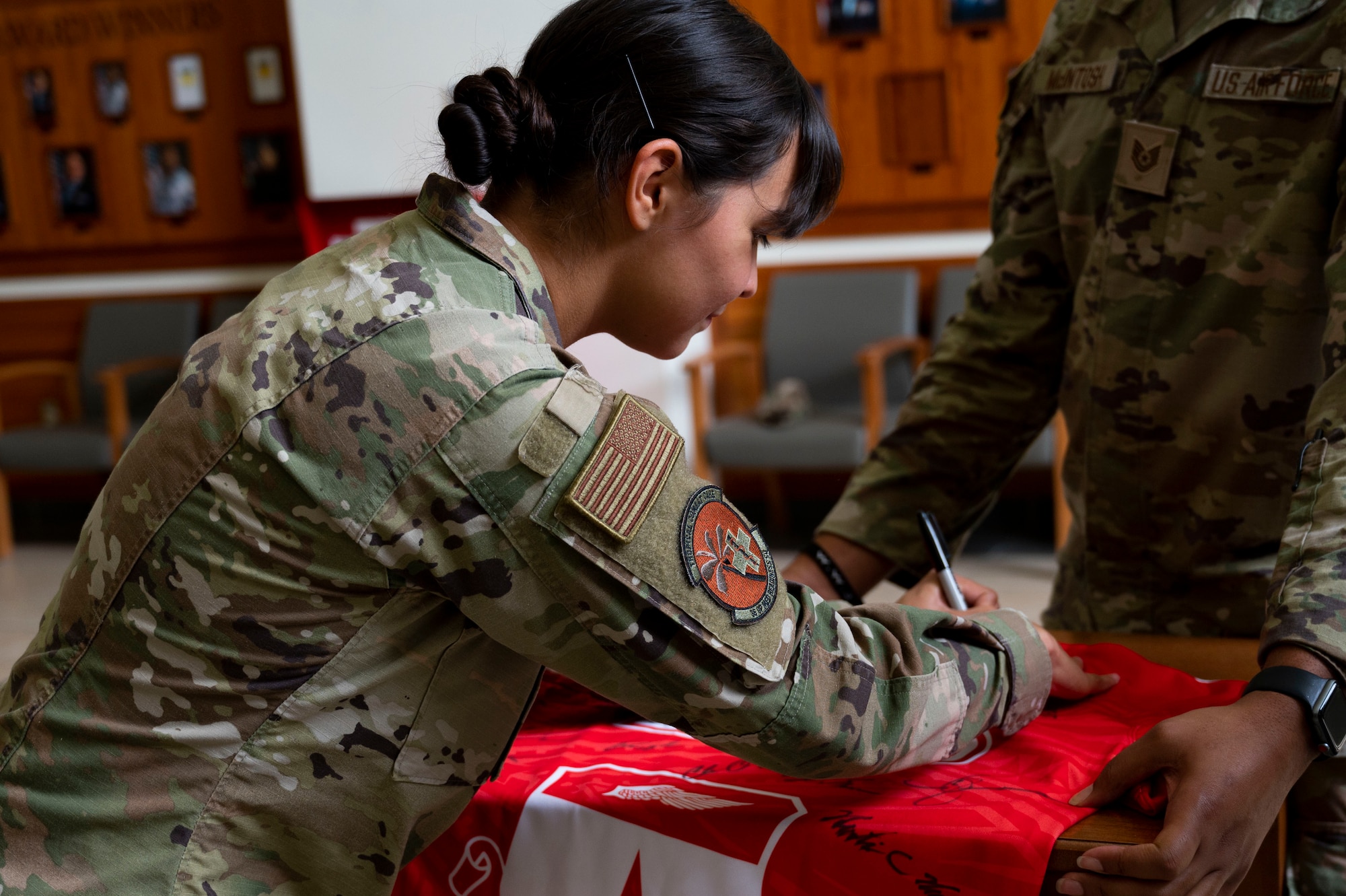 U.S. Air Force Senior Airman Alexandra Santos, dental prophylaxis technician assigned to the 36th Occupational Medical Readiness Squadron, signs the Linebacker of the Week jersey at Andersen Air Force Base, Guam, June 7, 2023. The Team Andersen Linebacker of the Week recognizes outstanding enlisted, officer, civilian and total force personnel who have had an impact on achieving Team Andersen’s mission, vision and priorities. (U.S. Air Force photo by Airman 1st Class Emily Saxton)