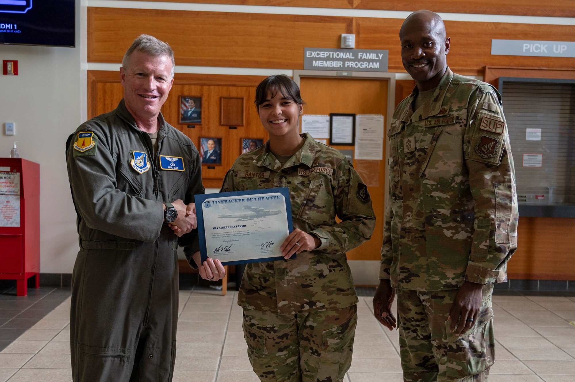 U.S. Air Force Senior Airman Alexandra Santos, dental prophylaxis technician assigned to the 36th Occupational Medical Readiness Squadron, receives the Linebacker of the Week Award from U.S. Air Force Brig. Gen. Paul Fast, commander of the 36th Wing, and U.S. Air Force Chief Master Sgt. Nicholas Taylor, the command chief of the 36th Wing, at Andersen Air Force Base, Guam, June 7, 2023. The Team Andersen Linebacker of the Week recognizes outstanding enlisted, officer, civilian and total force personnel who have had an impact on achieving Team Andersen’s mission, vision and priorities. (U.S. Air Force photo by Airman 1st Class Emily Saxton)