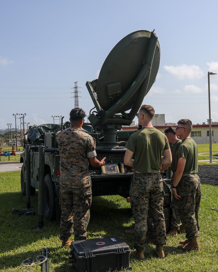 U.S. Marine Lance Cpl Robert Alcala, left, a satelite communications operator with Communication Co., Headquarters and Support Battalion, 3rd Marine Division, instructs Marines while setting up a Secure Mobile, Anti-Jam, Reliable Tactical Terminal during Fire Support Training-Joint aboard Camp Courtney, Okinawa, Japan, Apr. 24, 2023. (U.S. Marine Corps photo by Staff Sgt. Andrew Ochoa)