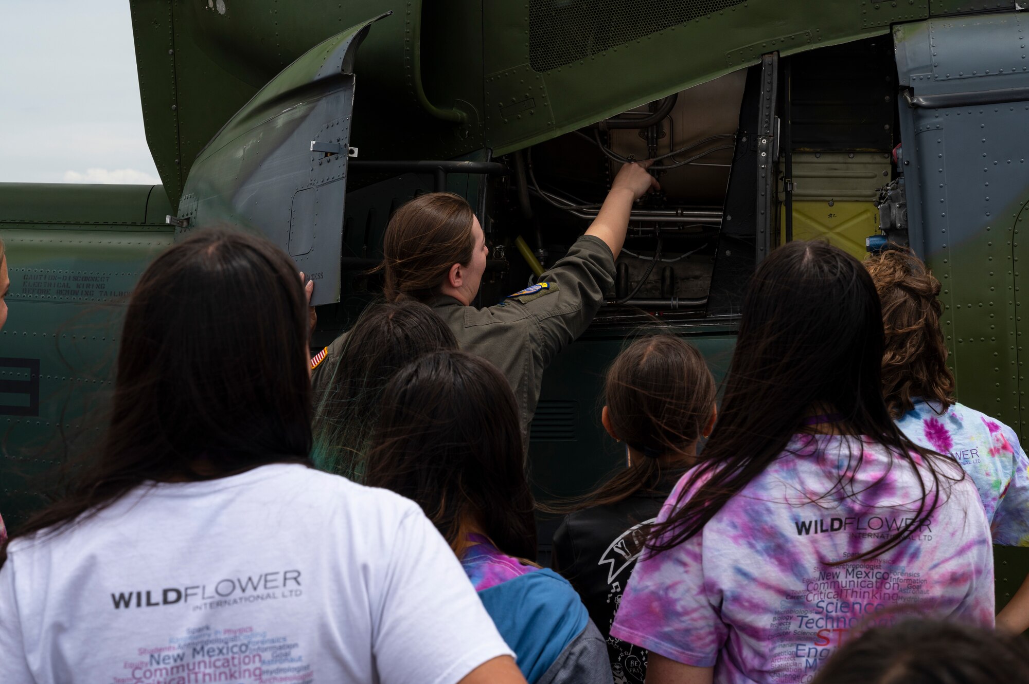 A group of students look at a helicopter.