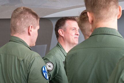 pilots talking around F-22 in hangar