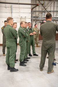 pilots talking around F-22 in hangar