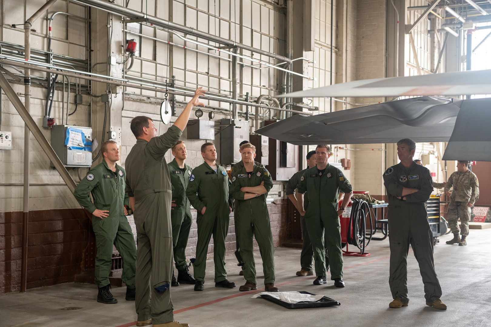 pilots talking around F-22 in hangar