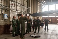 pilots talking around F-22 in hangar