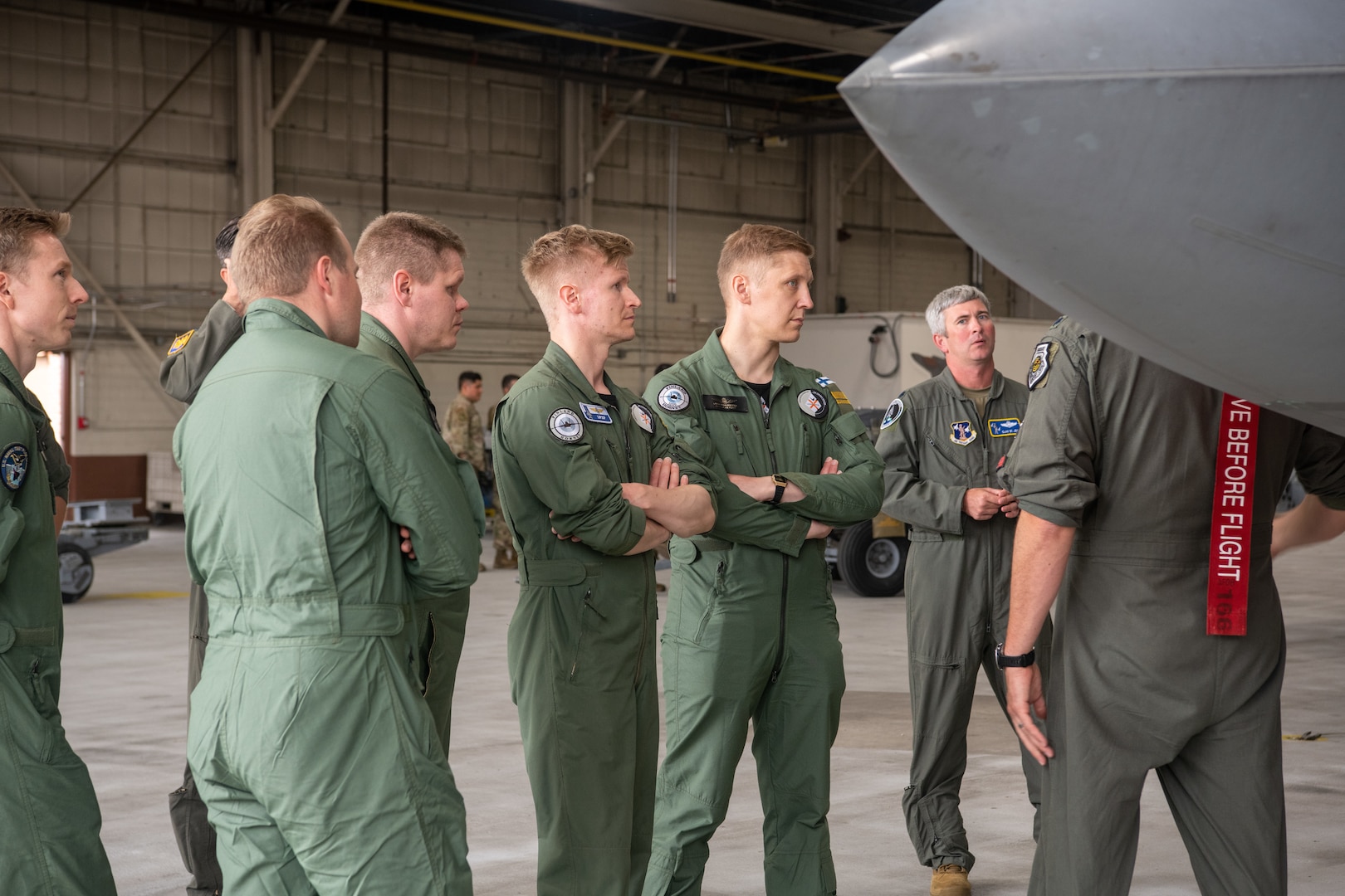 pilots talking around F-22 in hangar