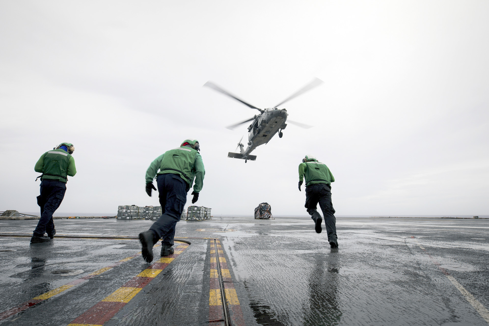 Sailors move to retrieve cargo on the flight deck aboard USS Nimitz (CVN 68).