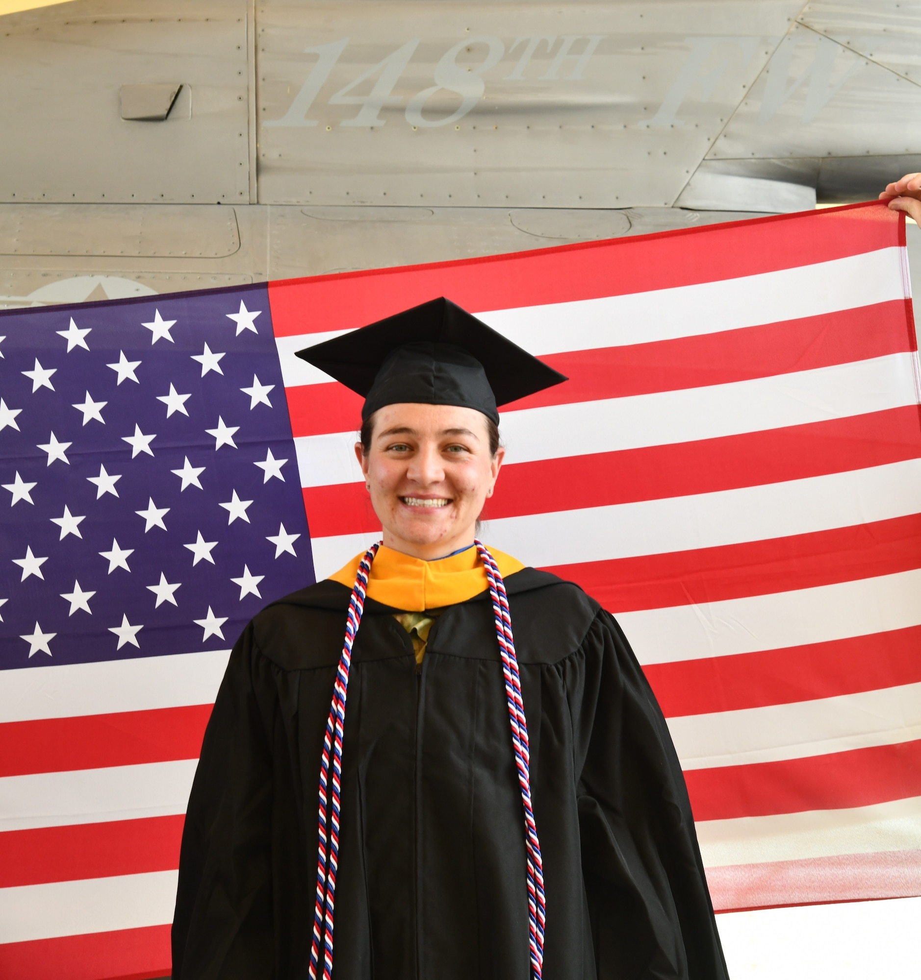 148th Supply Specialists, Staff Sgt. Amy Auran, assigned to the 148th Fighter Wing, Minnesota Air National Guard poses for a photo in front of an F-16 Fighting Falcon in honor of her college graduation on May 12, 2022