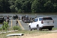 Soldiers from the Kentucky National Guard’s 2061st Multi-Role Bridge Company load vehicles onto their raft bridge to be transported to the other side of the lake during the Homeland Defender Exercise