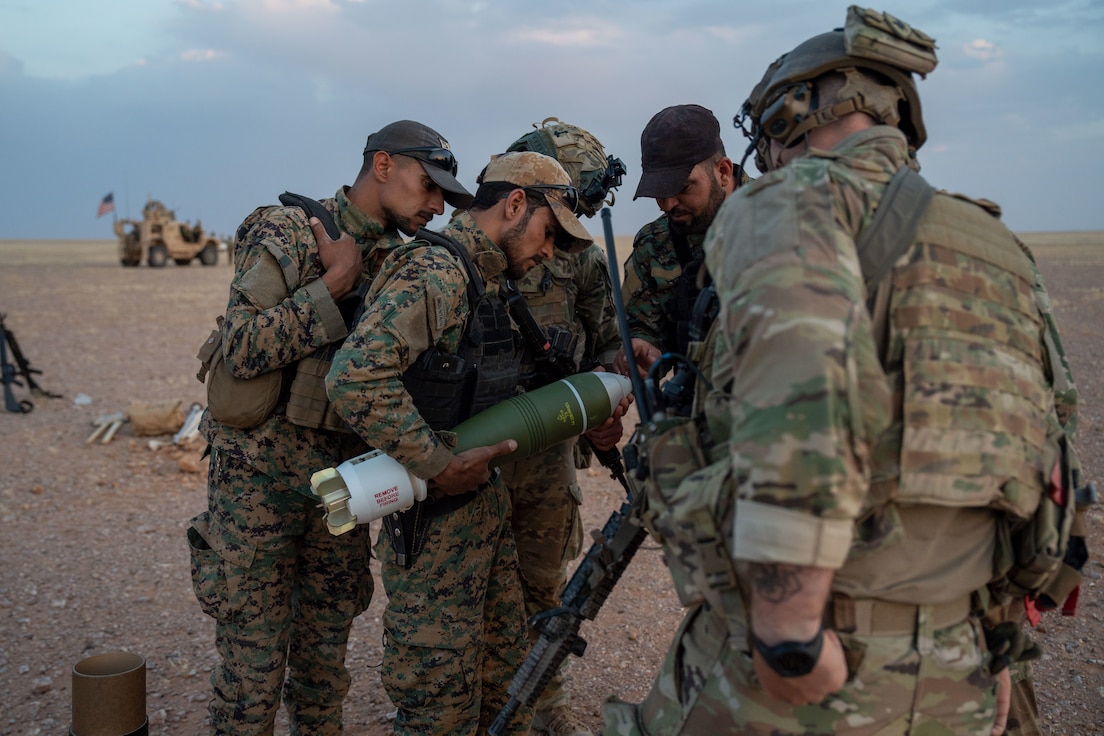 Partner Force members inspect a mortar round before use in the al-Tanf region, Syria.
