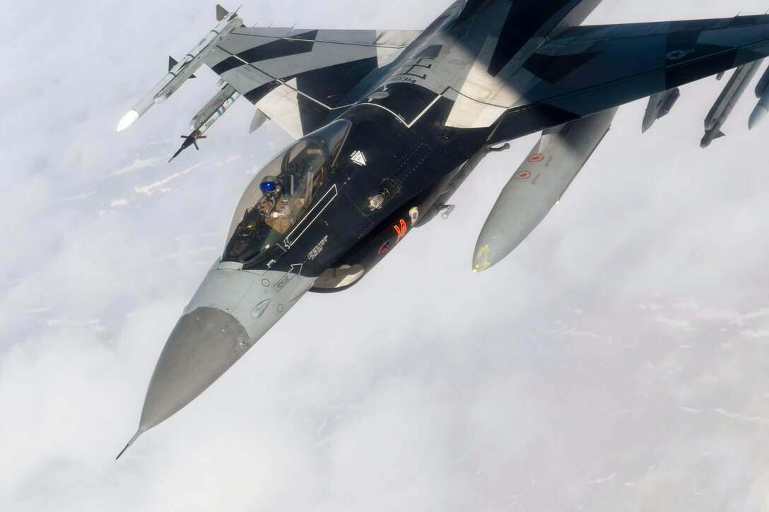 An aircraft flies in a downward angle through the clouds.