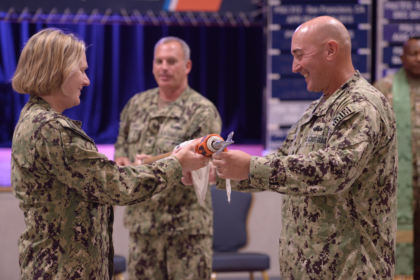 U.S. Coast Guard Commandant Adm. Linda Fagan and Cmdr. James Lovenstein, Port Security Unit (PSU) 305’s commanding officer, roll the unit guidon as Master Chief Petty Officer Thomas Lepage, PSU 305’s command master chief, extends it during the unit’s casing of the colors decommissioning ceremony at Naval Station Guantanamo Bay, Cuba, June 13, 2023.

PSU 305, based in Fort Eustis, Va., was the first unit in 2002 to begin the Coast Guard’s mission with Joint Task Force Guantanamo Bay and is the last to complete it. (U.S. Coast Guard photo by Petty Officer 1st Class Valerie Higdon)