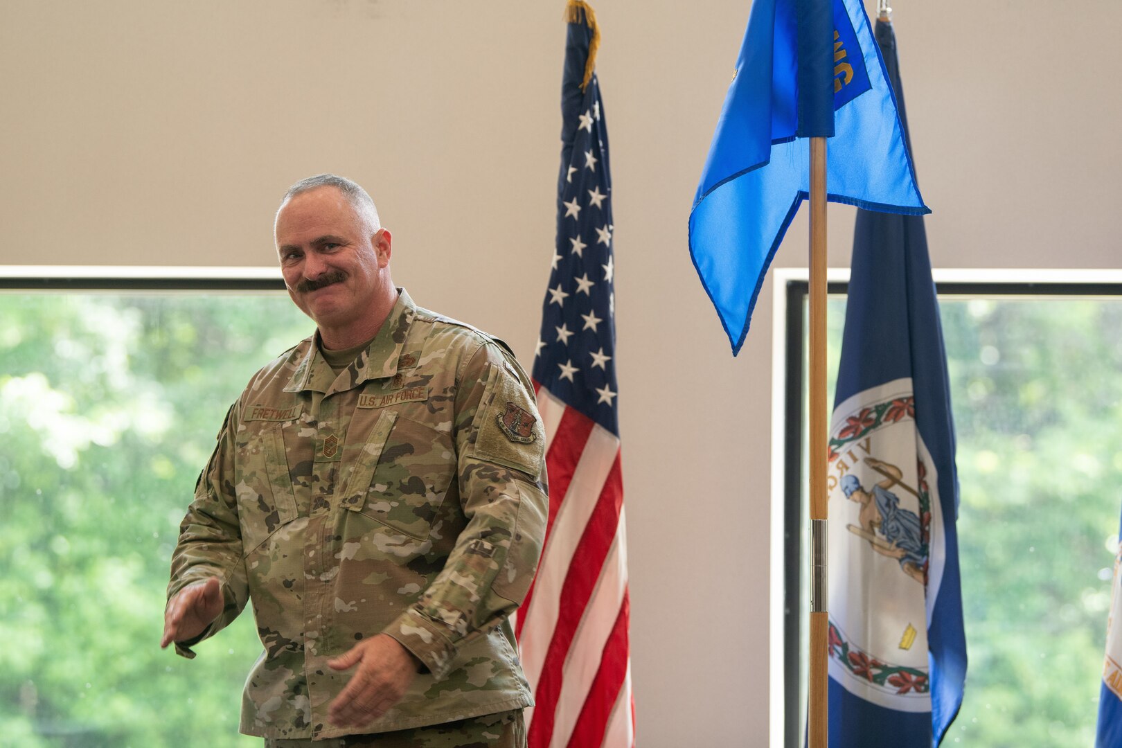 Chief Fretwell standing on stage next to 192nd Wing guidon