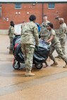 group of Airmen pushing cart of equipment