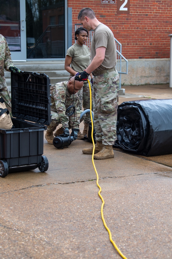 Airman plugging in power source for tent
