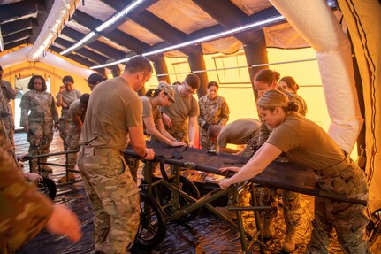 group of Airmen setting up medical transport gurney