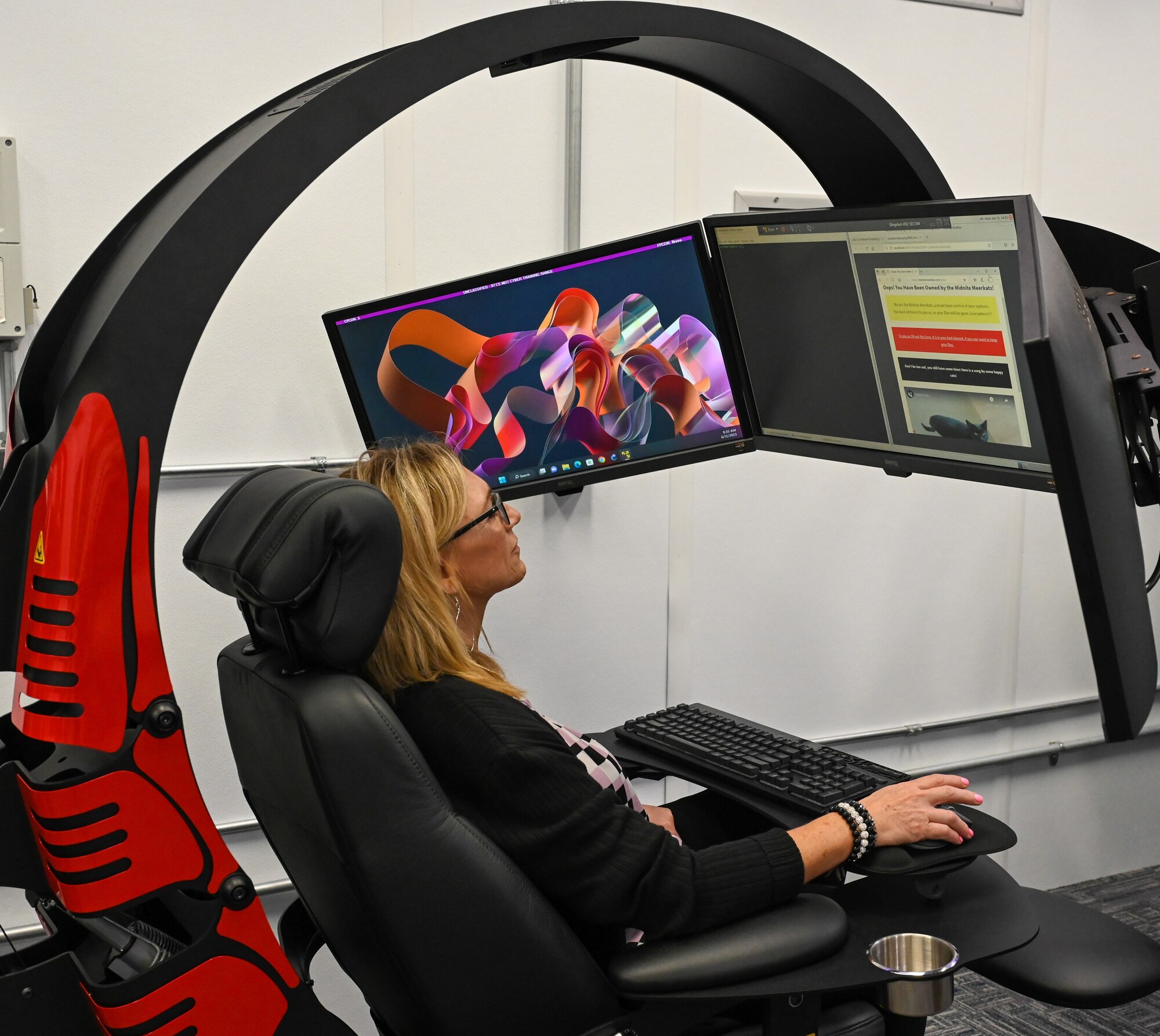 Chrystal Overton, 97th Communications Squadron honorary commander, sits in a simulated computer process improvement chair during a base tour at Altus Air Force Base, June 12, 2023. The chairs are used by cyber-security students during training. (U.S. Air Force photo by Airman 1st Class Heidi Bucins).