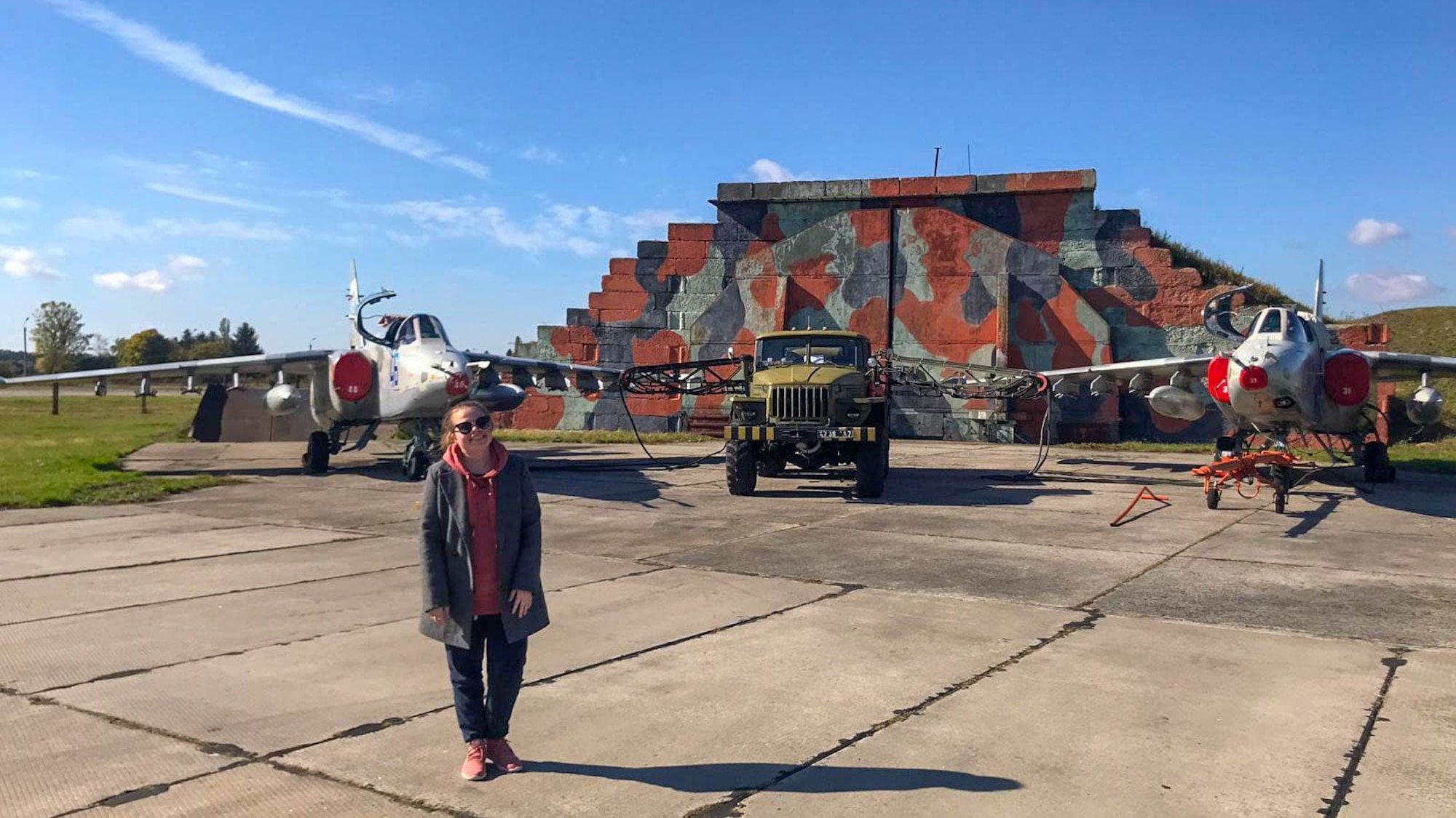 U.S. Air Force Master Sgt. Maria Jarr, 607th Air Control Squadron flight chief, stands in front of a display containing two Ukrainian Sukhoi Su-25 Grach aircraft, October, 2018, at Starokostiantyniv Air Base, Ukraine.