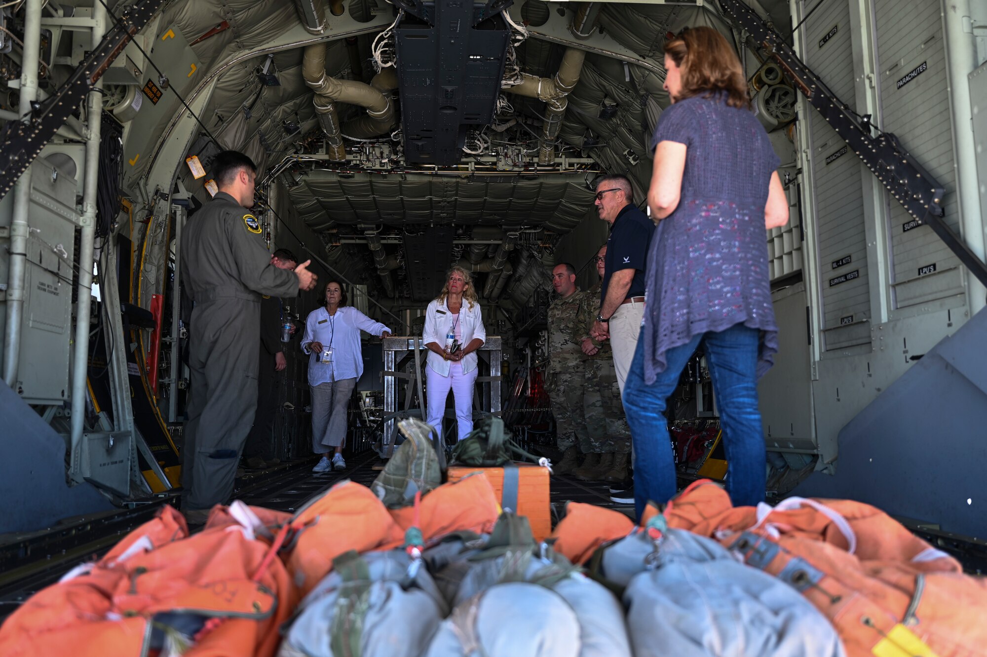 A group of people stand in an aircraft.