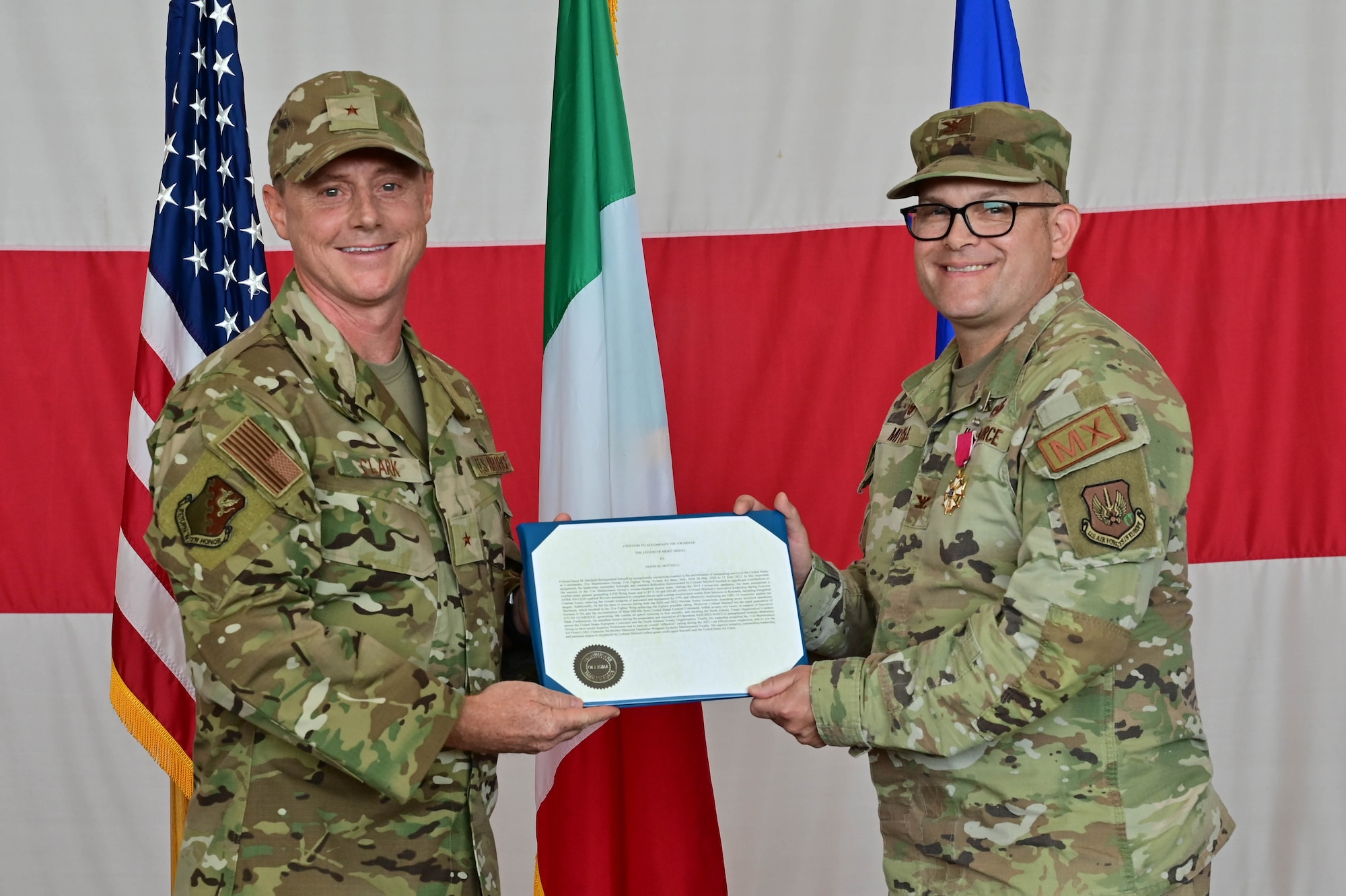 U.S. Air Force Brig. Gen. Tad Clark, 31st Fighter Wing commander, presents a certificate to U.S. Air Force Col. Jason Mitchell, 31st Maintenance Group outgoing commander, at Aviano Air Base, Italy, June 15, 2023. The 31st Maintenance Group responds to humanitarian and contingency logistics support requirements in Europe, African and Southwest Asia. (U.S. Air Force photo by Airman Zachary Jakel)