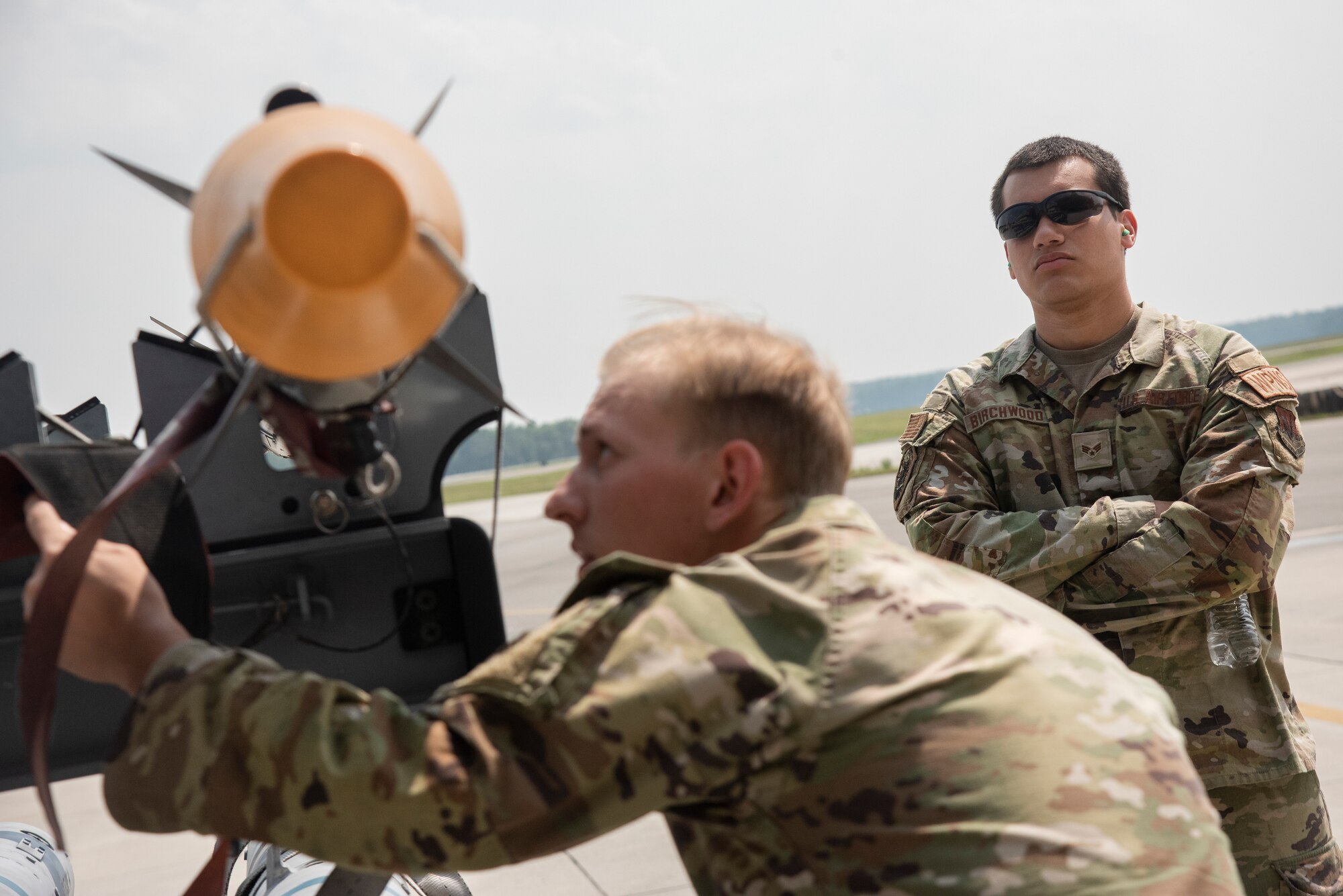 Senior Airman Canaan Birchwood, right, 4th Maintenance Group loading standardization crew member, evaluates Airman 1st Class Isaac Bergfield, 335th Fighter Generation Squadron weapons load crew member, during a weapons standardization load evaluation.