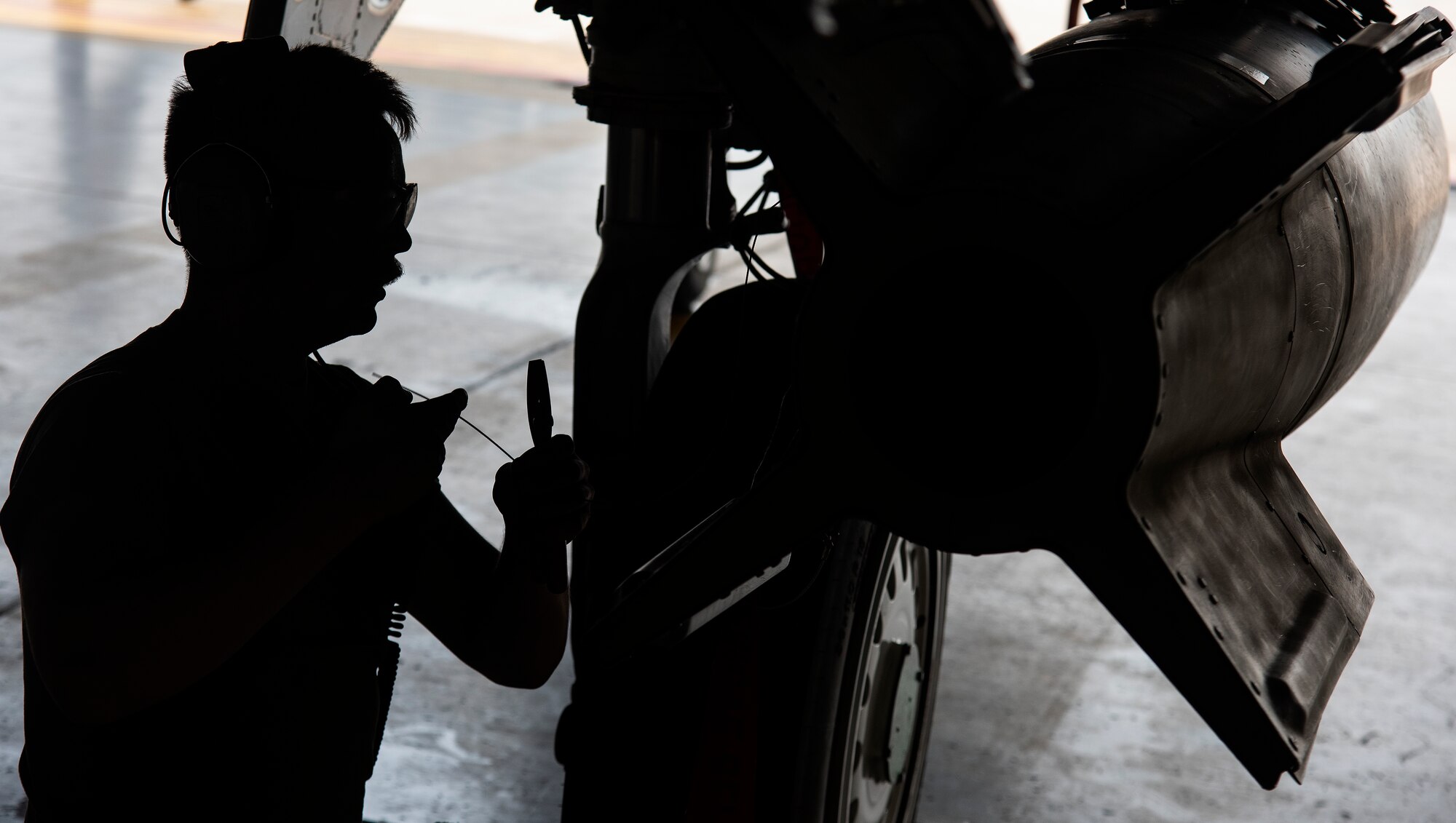 Senior Airman Mitchell Sanborn, 335th Fighter Generation Squadron weapons load crew member, loads an unarmed practice [GBU-10 Paveway II] munition onto an F-15E Strike Eagle.