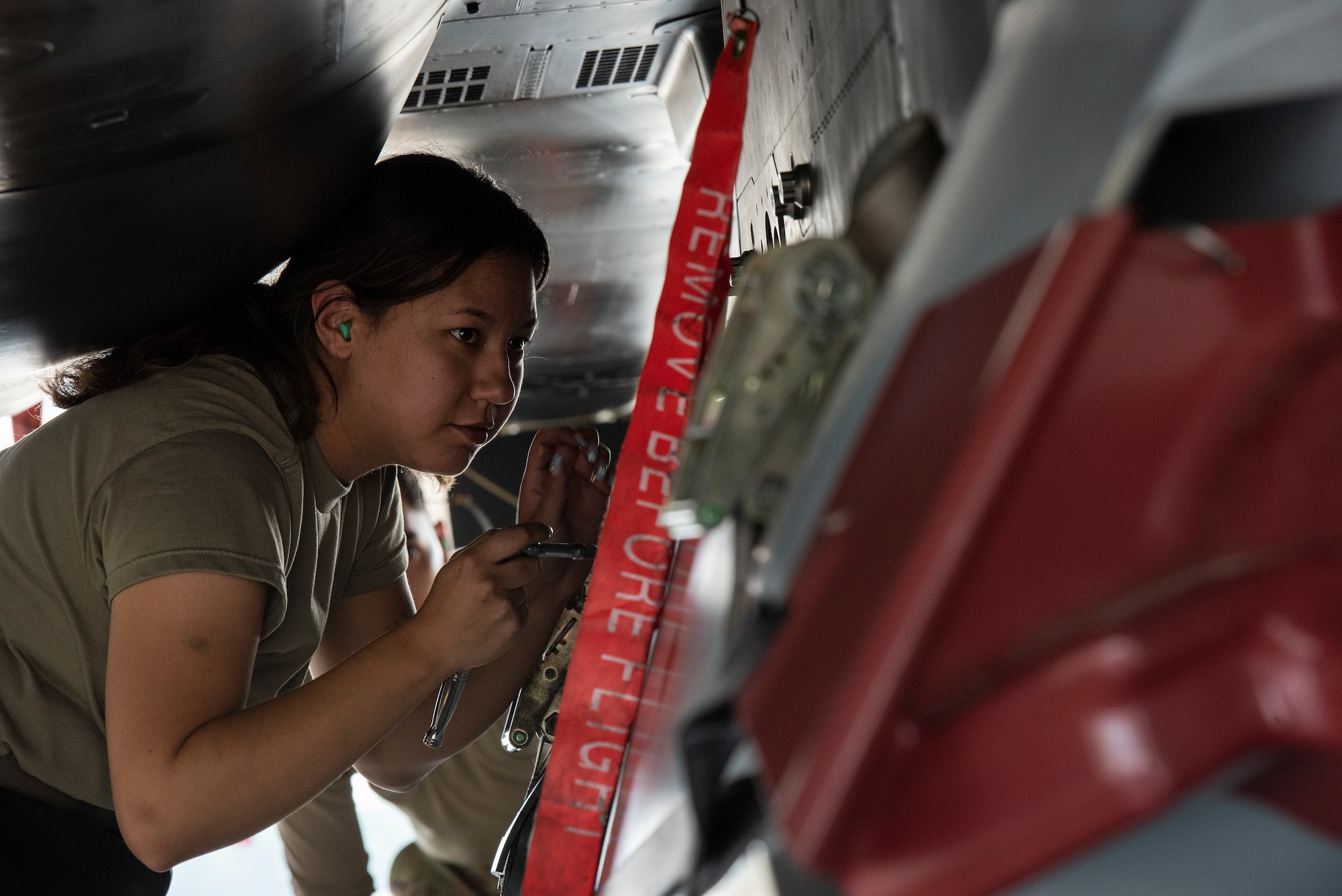 Senior Airman Cassandra Romero, 333rd Fighter Generation Squadron weapons load crew member, loads and secures an unarmed practice [AGM-158 JASSM] munition onto an F-15E Strike Eagle.