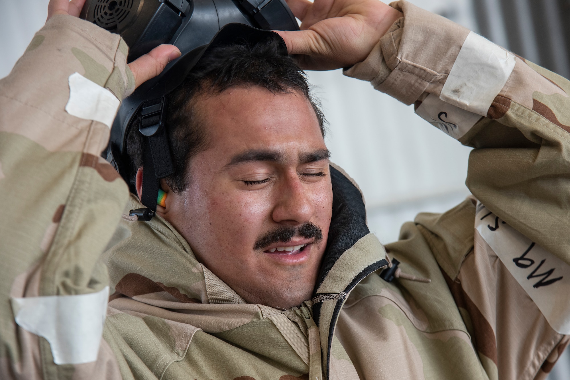 Airman 1st Class Jean Vega-Lopez, 336th Fighter Generation squadron weapons load crew member, takes off his chemical, biological, radiological, nuclear, and explosive (CBRNE) gear after completing a weapons standardization load evaluation.