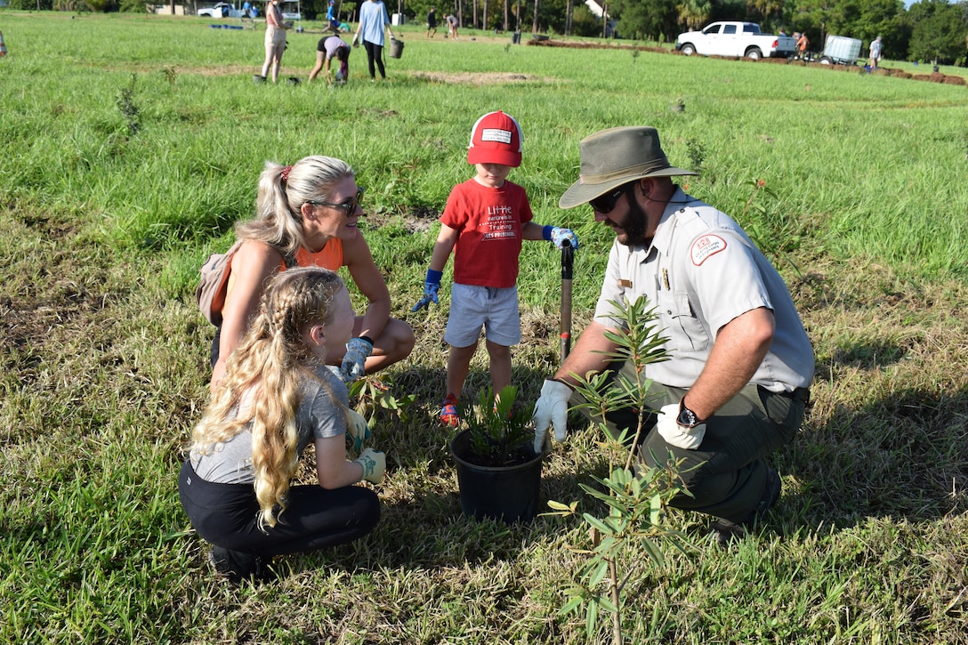 Ranger Rob Hill teaches volunteers of all ages how to plant natives so they will thrive.