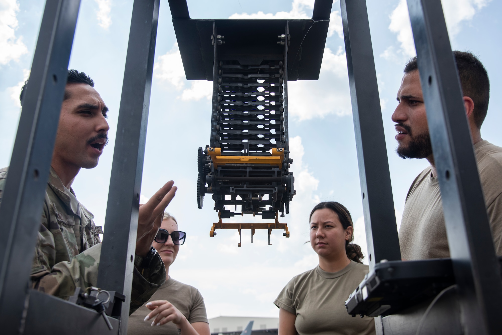 Staff Sgt. Alexandro Diaz, left, 4th Maintenance Group loading standardization crew member, familiarizes weapons load crew members on how to hookup a Linkless Ammunition Loading System.