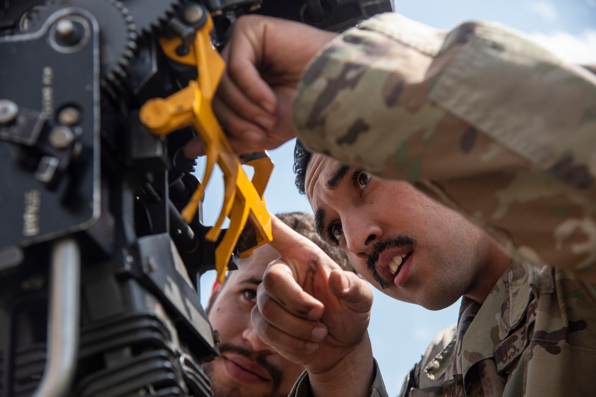 Staff Sgt. Alexandro Diaz, right, 4th Maintenance Group loading standardization crew member, shows Staff Sgt. Miguel Jiminez Flores, 336th Fighter Generation Squadron weapons load crew team chief, how to hookup a Linkless Ammunition Loading System.