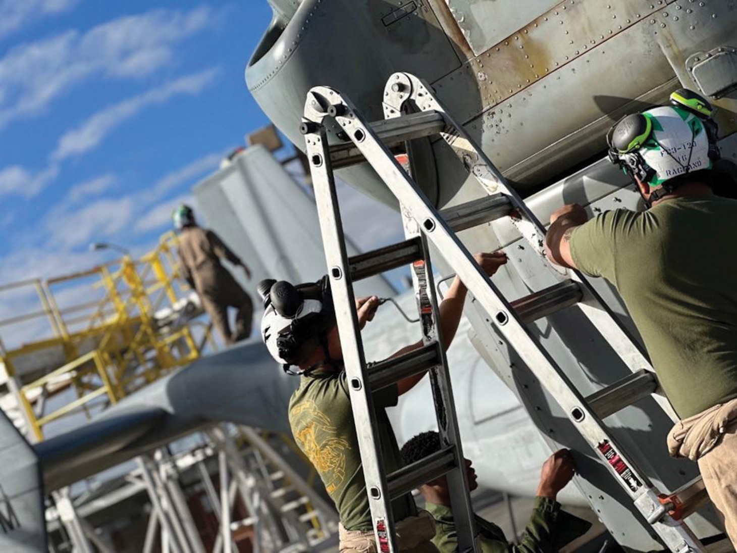 The Naval Aircrew Systems Program Office is fielding new headgear, the Head Gear Unit Number 98/Personal Use (HGU-98P) cranial that improves both head and hearing protection for fleet Marine Corps aviation maintainers. Pictured are two aviation maintainers at Marine Corps Air Station Miramar, California, using the HGU-98P. From left are the HGU-98 X5 and the HGU-98 X4.